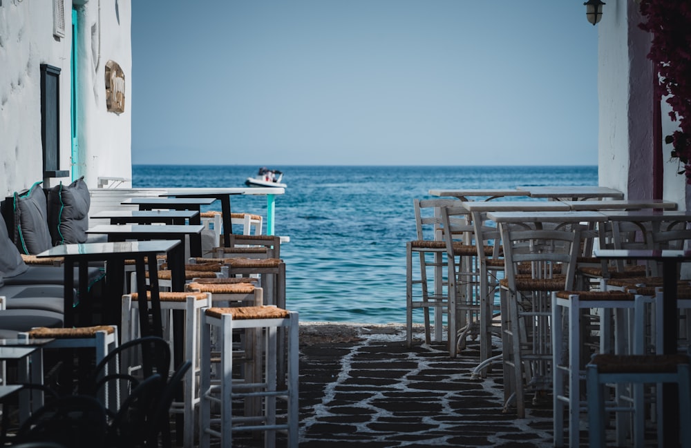 a row of tables sitting next to the ocean