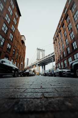 street photography,how to photograph instagram @lgnwvr | lgnwvr.com; a city street with cars and a bridge in the background