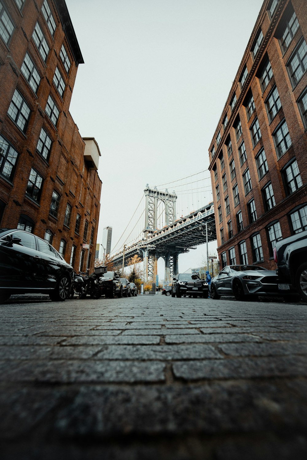 a city street with cars and a bridge in the background