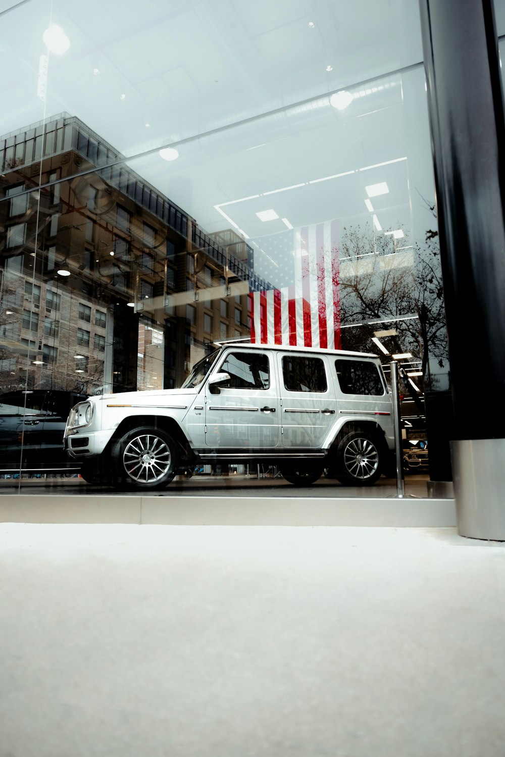 a white suv parked in front of a building with an american flag on it