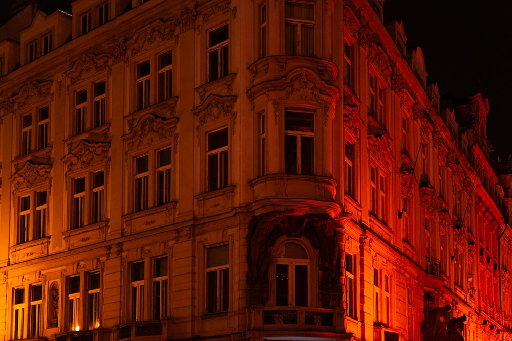 a large building lit up at night with red lights