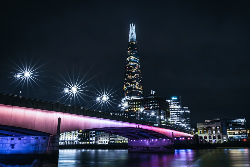 a bridge over a river with a city in the background