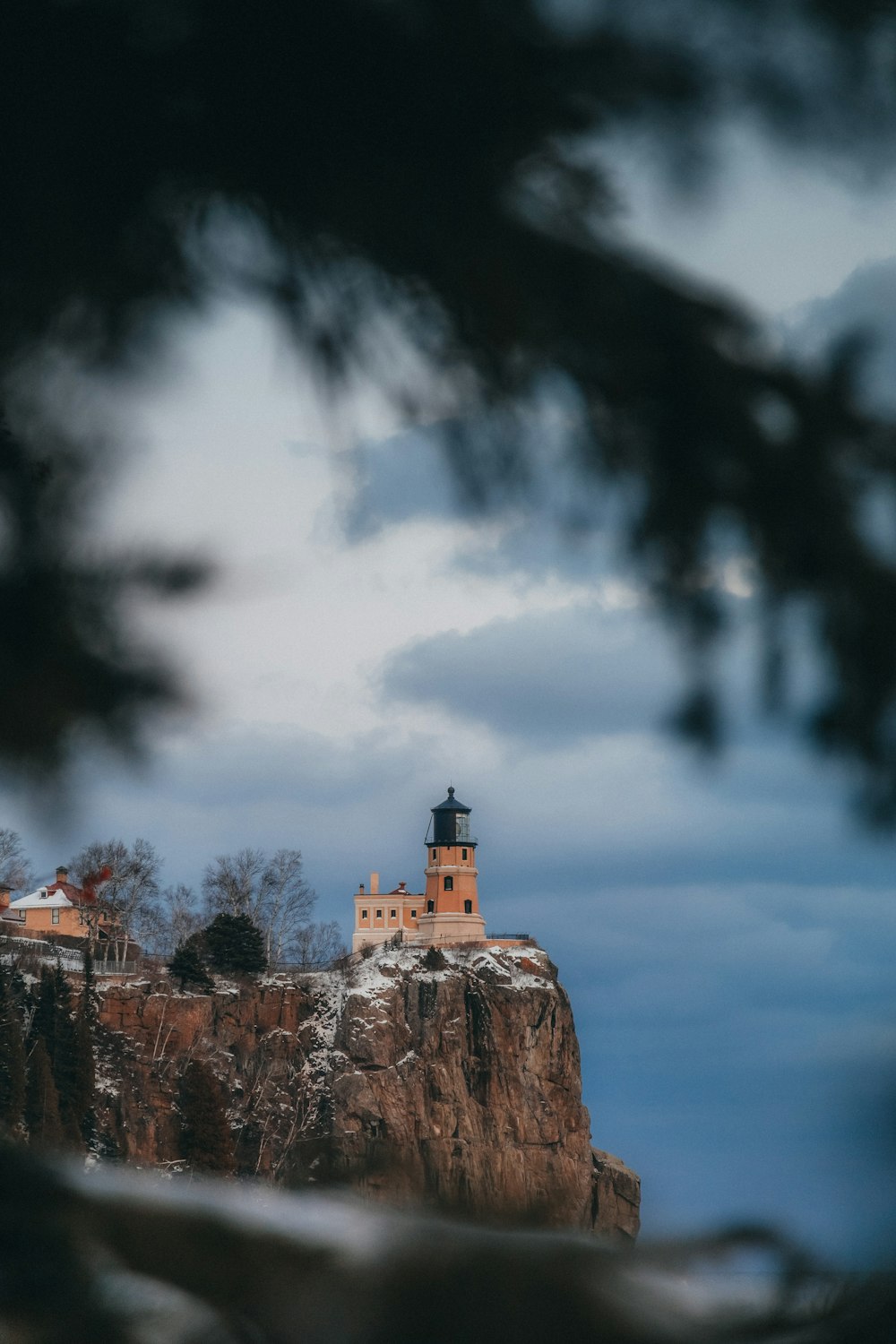 a lighthouse on top of a mountain with a sky background