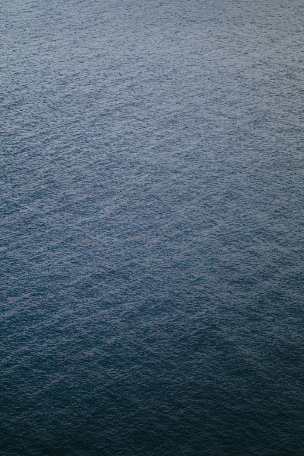 a large body of water with a boat in the distance