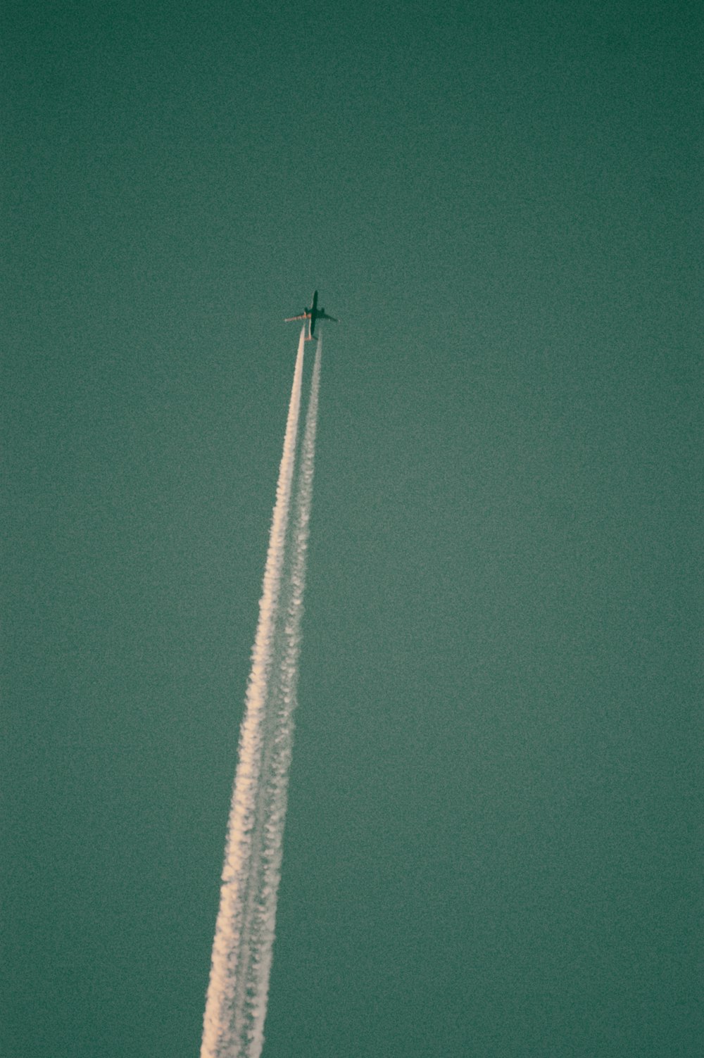 a jet flying in the sky leaving a trail of smoke behind it