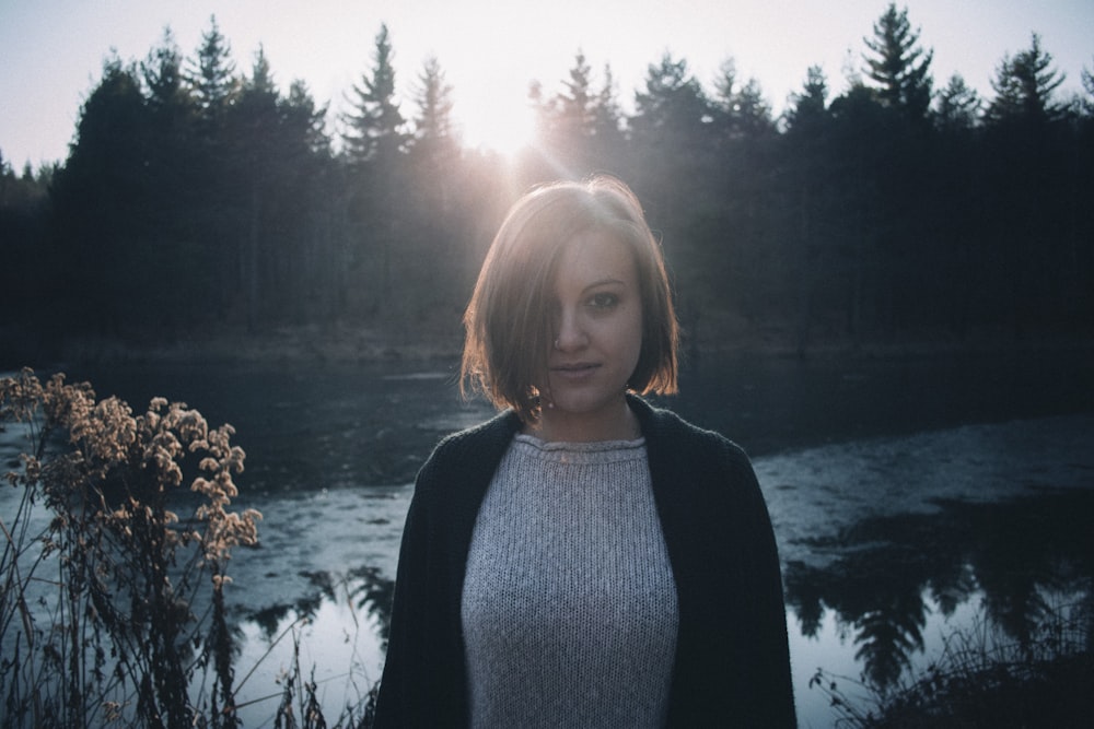 a woman standing in front of a body of water