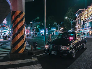 A Veloceway taxi waiting at a busy city street corner in Portsmouth during golden hour.
