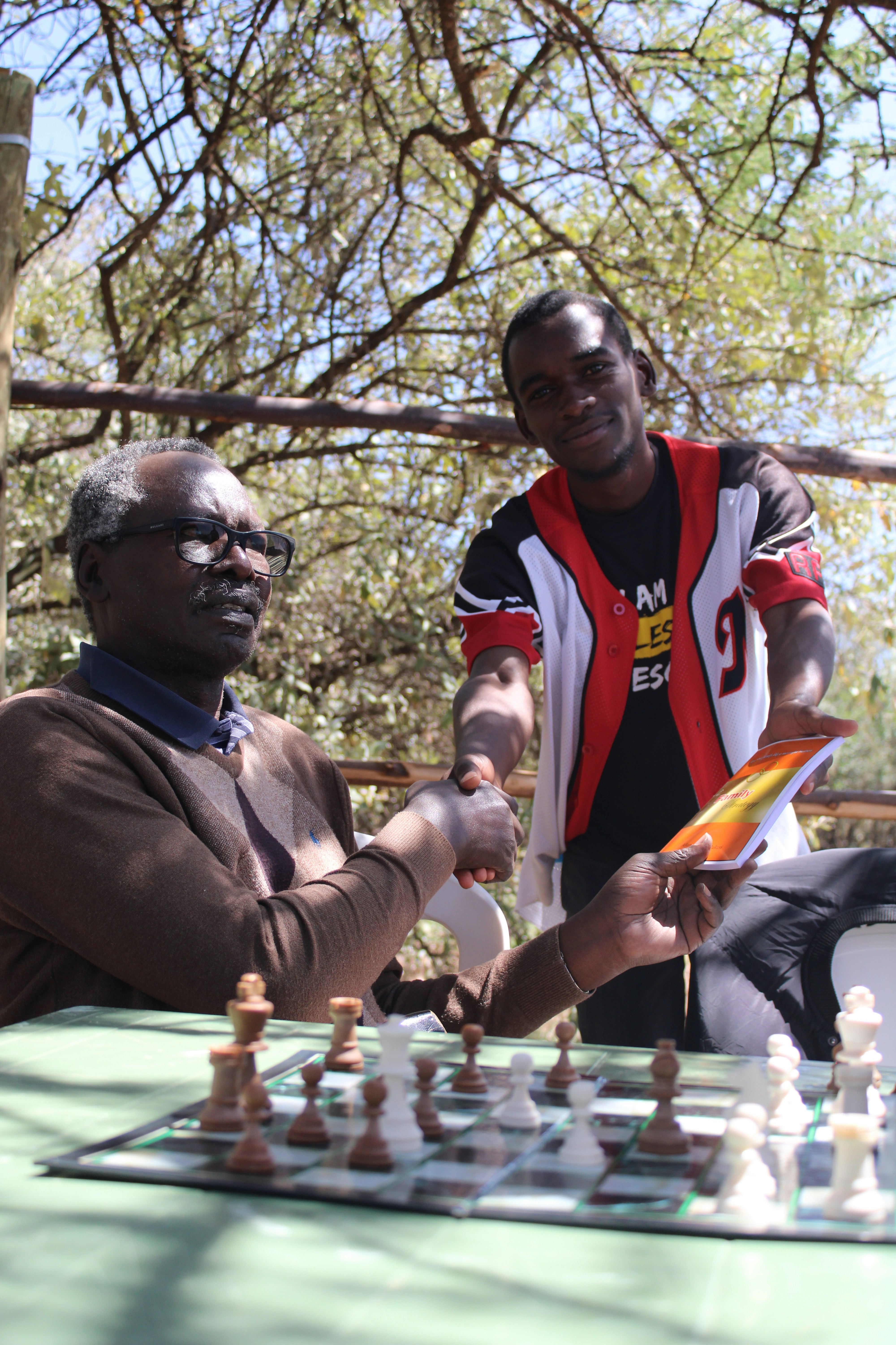 two men playing a game of chess outdoors