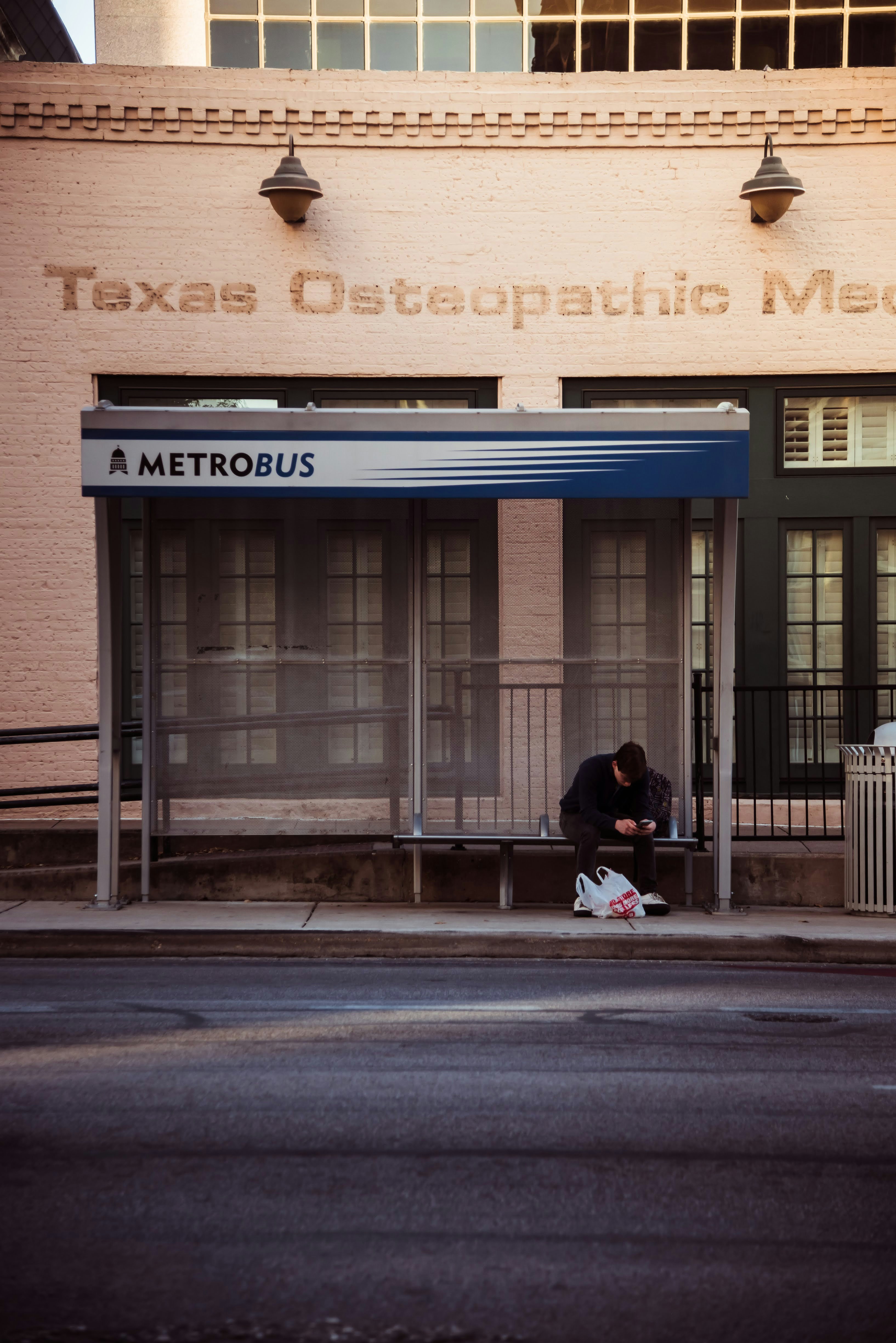A man sitting on a bench in front of a building