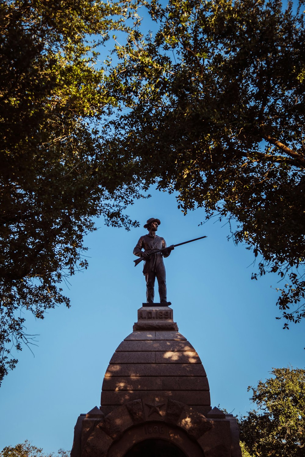 a statue of a man holding a rifle on top of a building