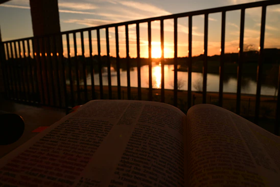 A serene sunset over an open Bible with highlighted passages about the rapture.