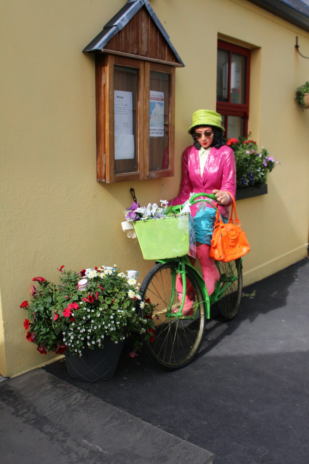 uma mulher em pé ao lado de uma bicicleta com flores na cesta