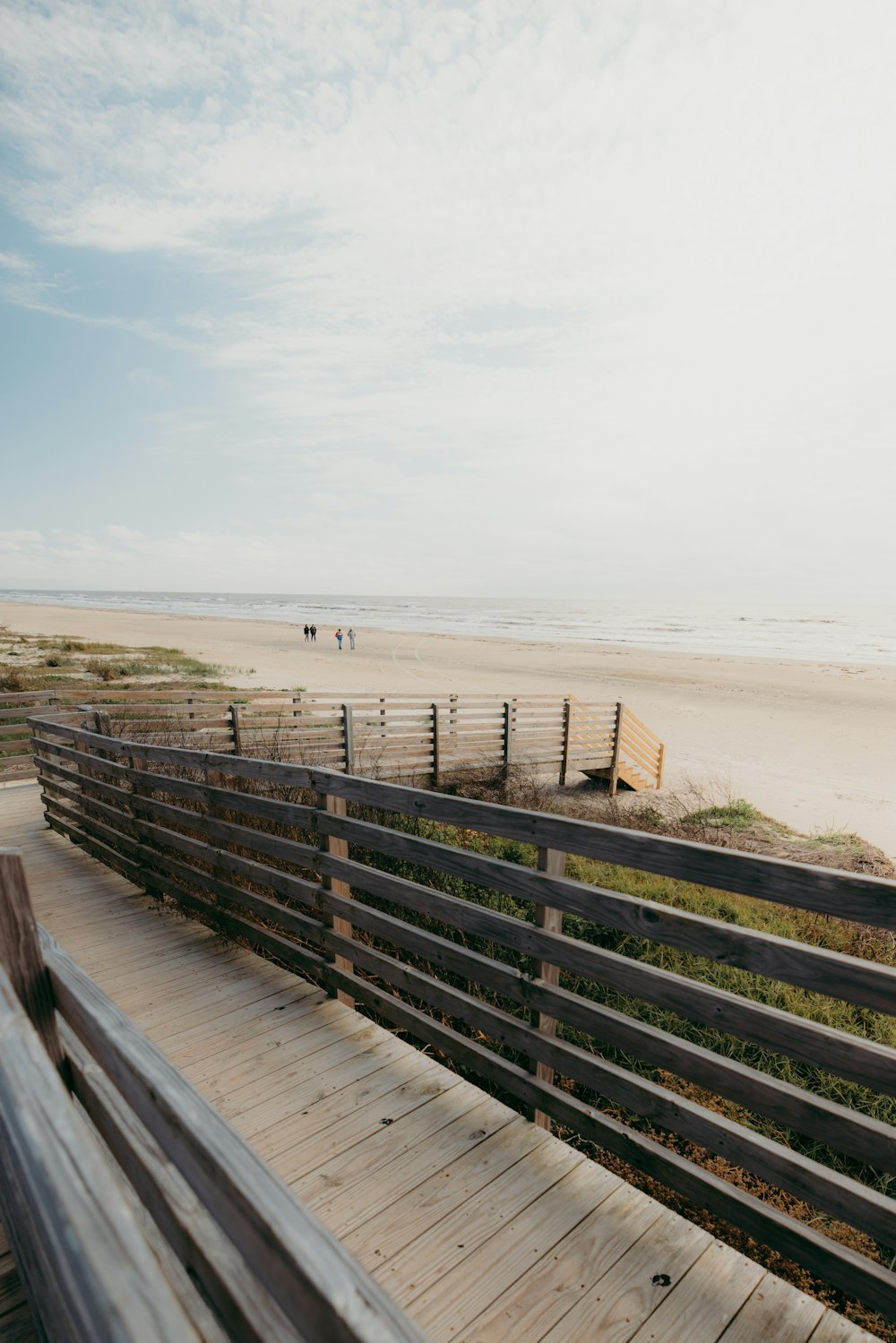 a wooden bench sitting on top of a sandy beach