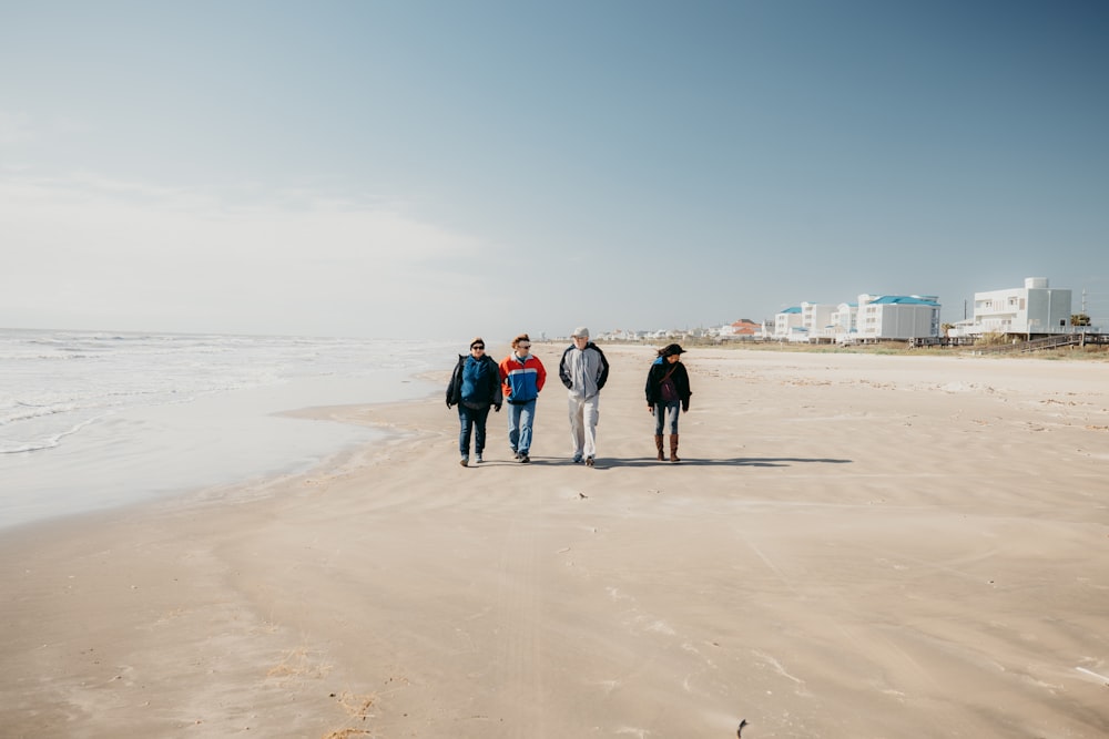 a group of people standing on top of a sandy beach