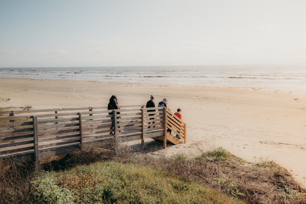 a group of people standing on top of a wooden fence