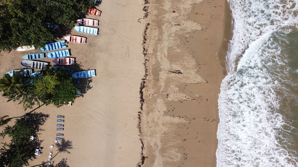 an aerial view of a beach with several boats