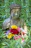 A peaceful park scene with a Buddha bear statue surrounded by blooming flowers.