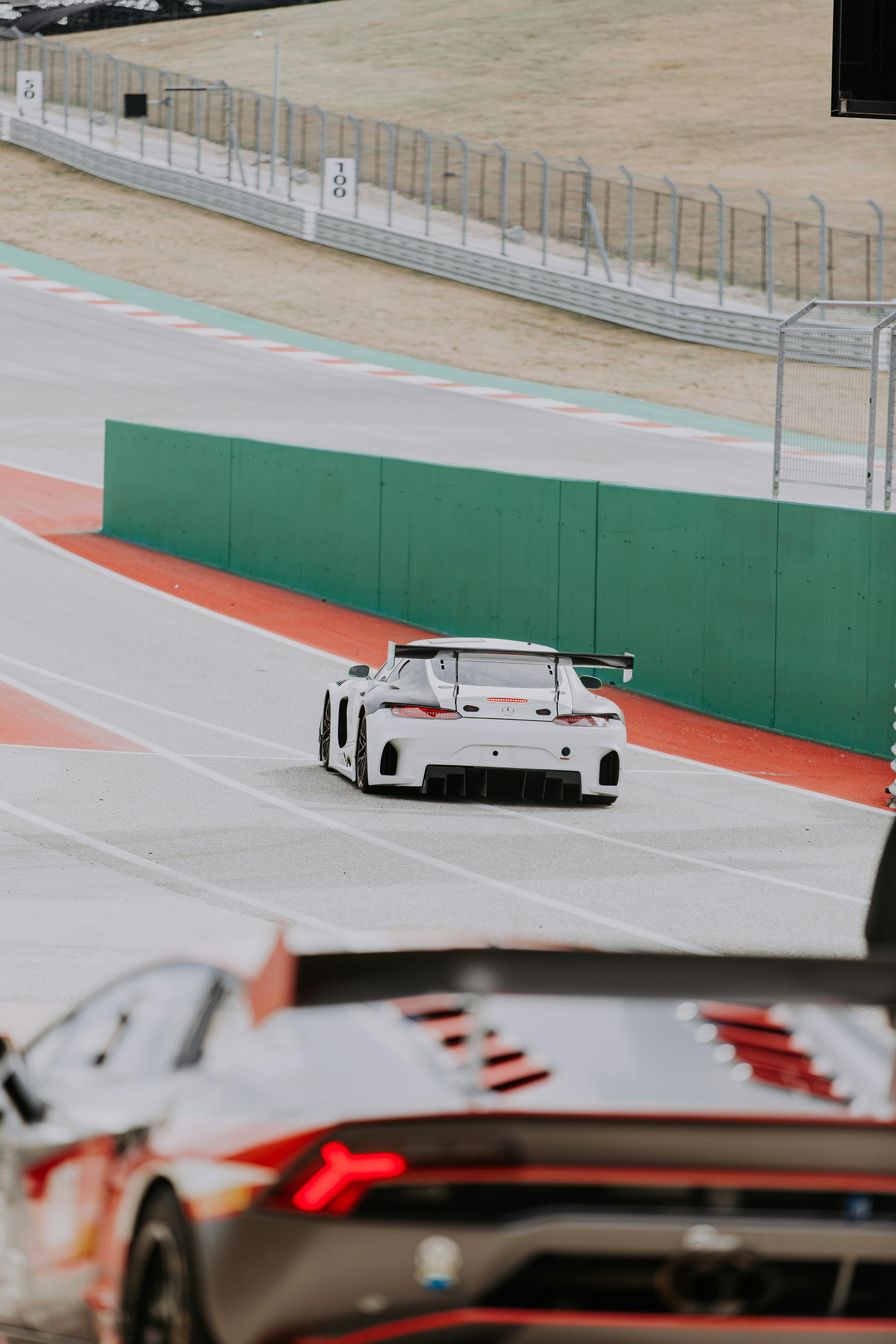 a white car driving down a race track