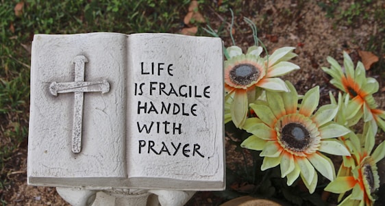 a statue of a book with a cross on it