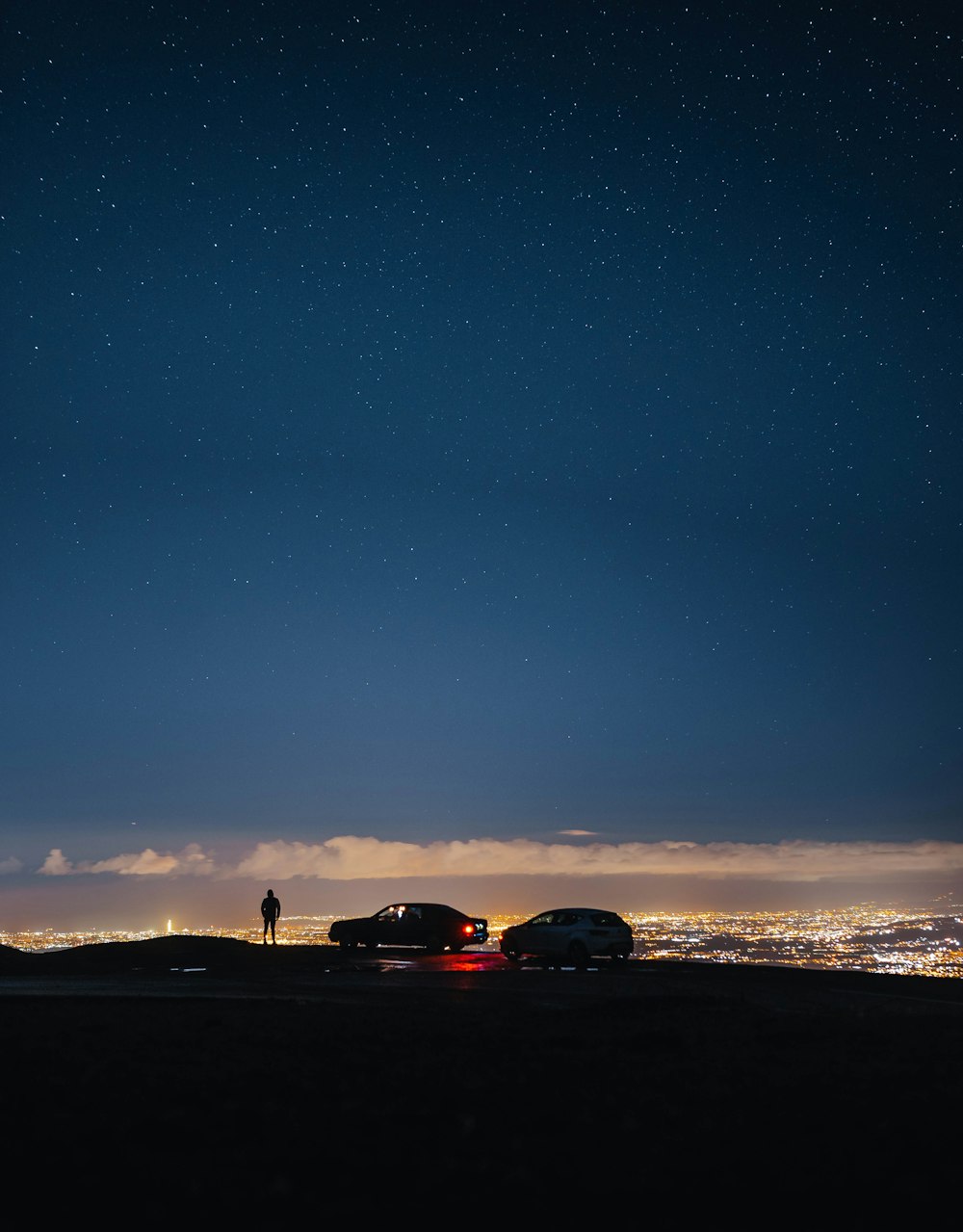 a couple of cars parked on top of a hill