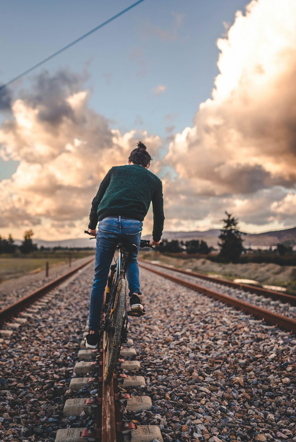 a man riding a bike down a train track