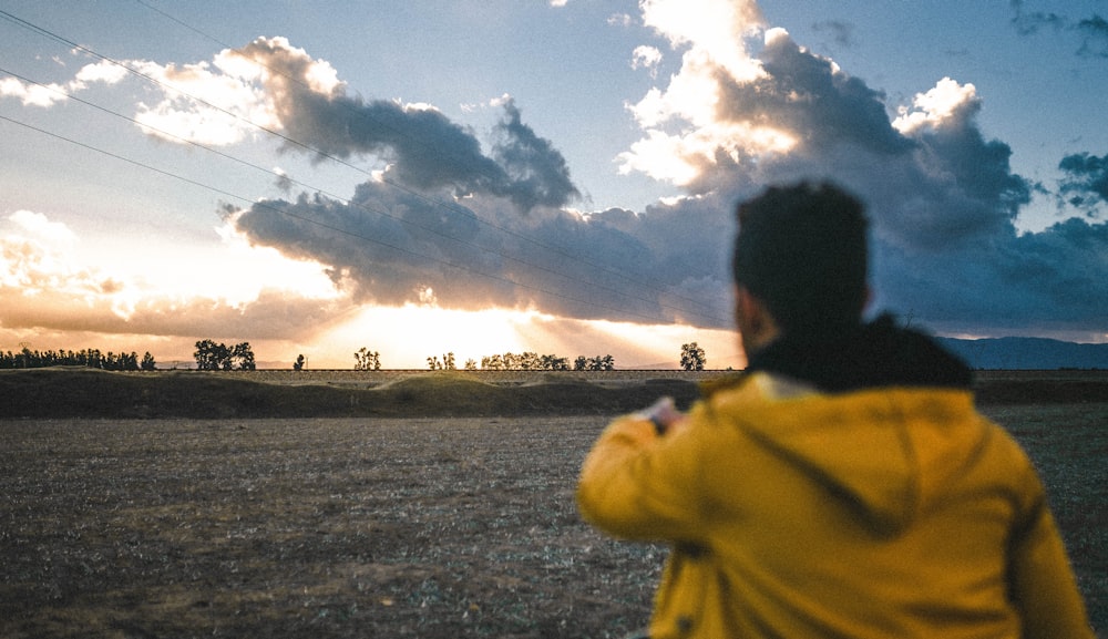 a man in a yellow jacket flying a kite