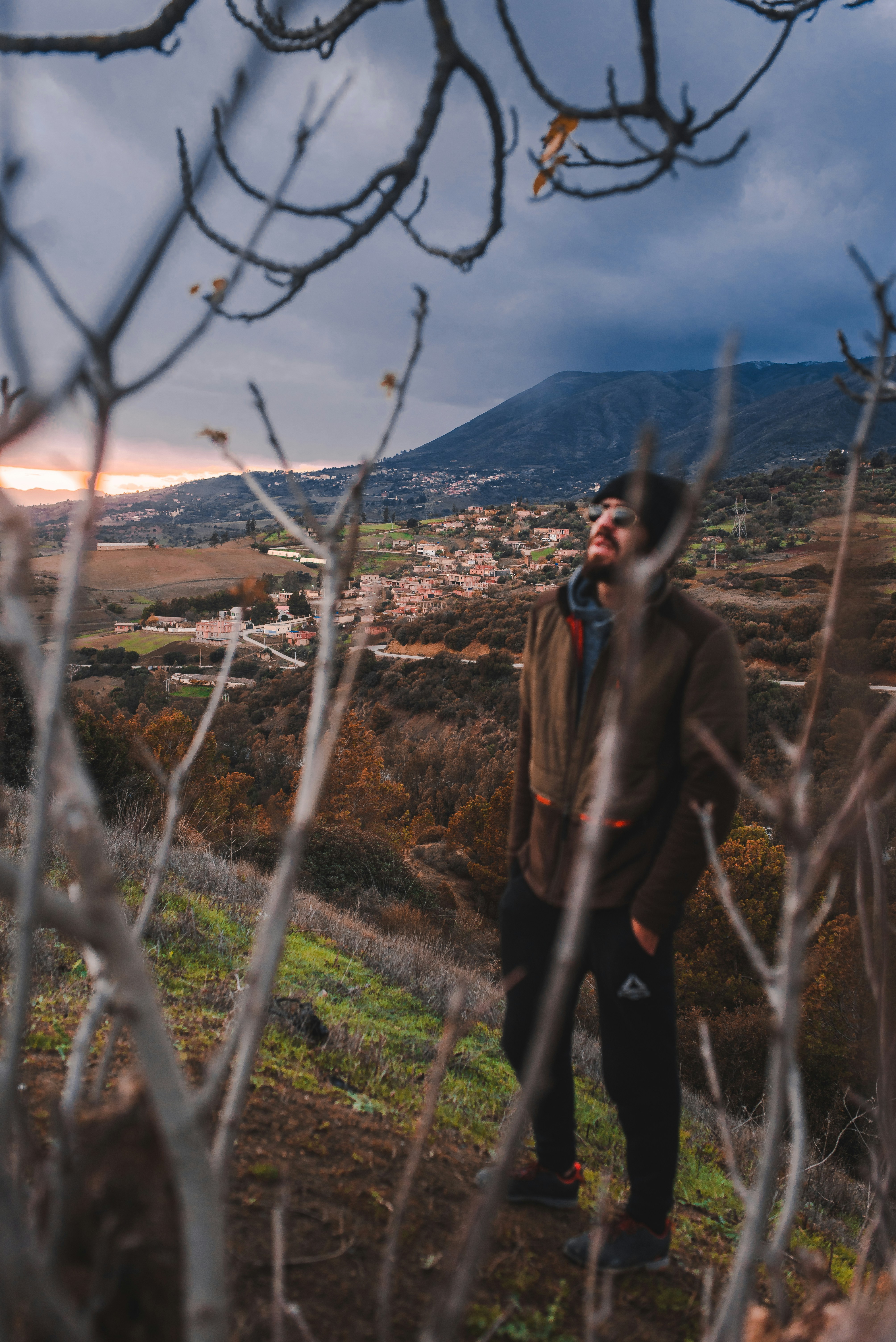 Un hombre parado en la cima de una exuberante ladera verde