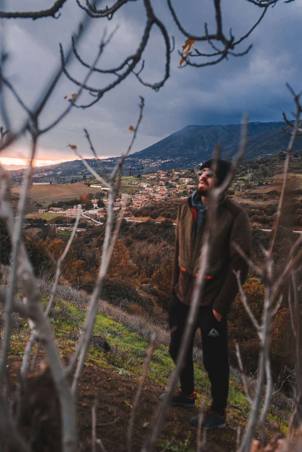 a man standing on top of a lush green hillside