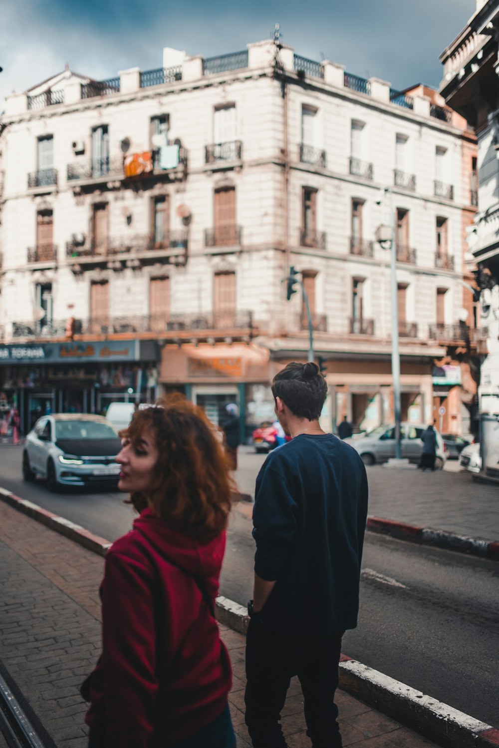 a man and a woman standing on the side of a road