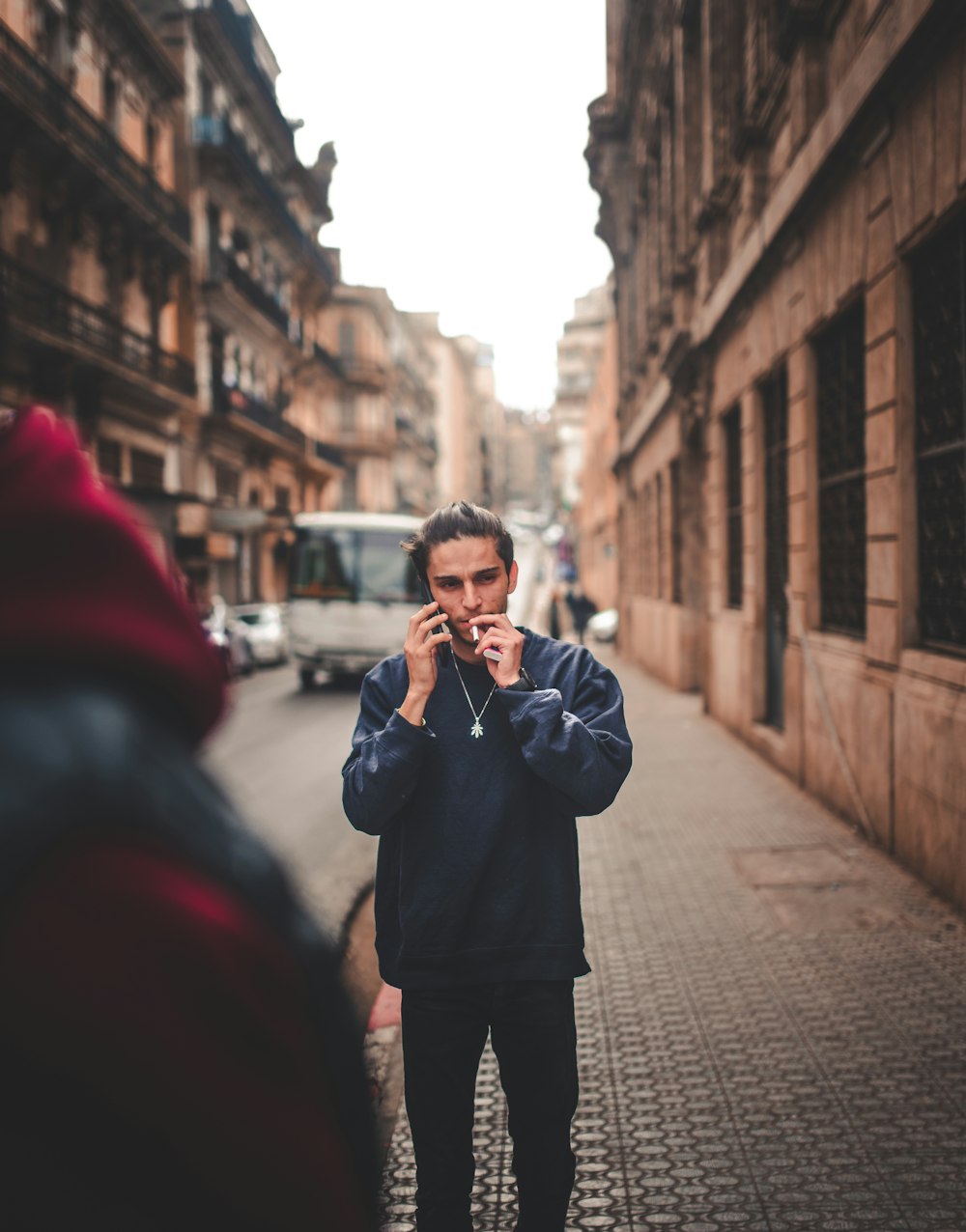 a man standing in the middle of a street talking on a cell phone