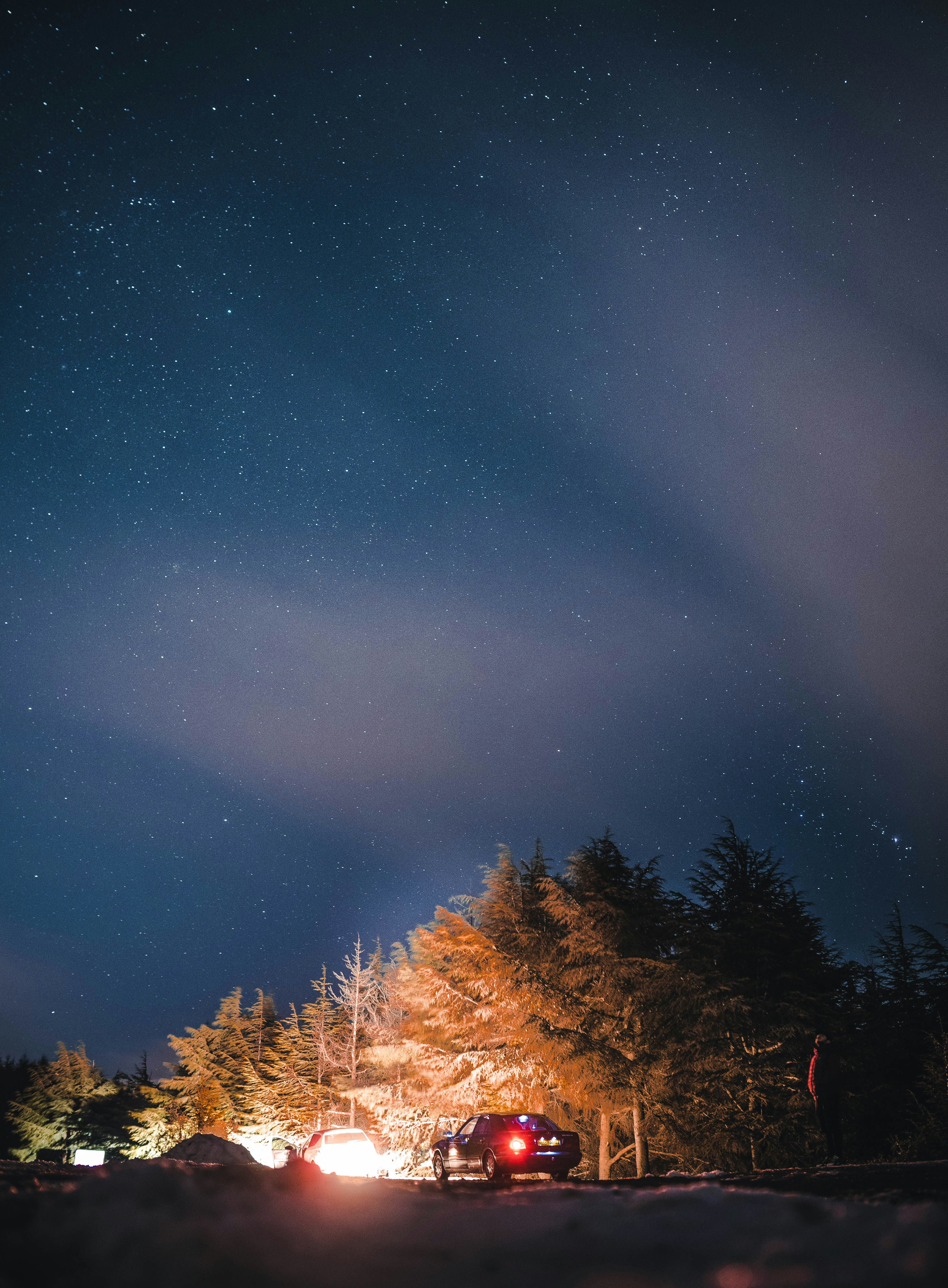 Un coche está aparcado en la nieve bajo las estrellas