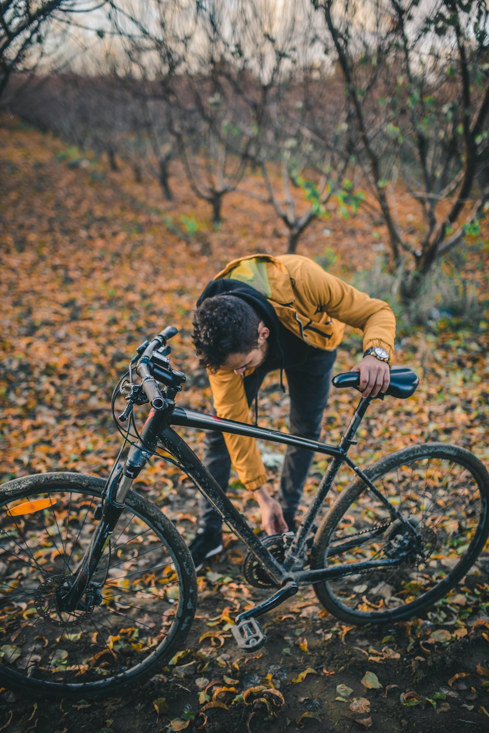숲 속에서 자전거를 타고 몸을 굽히는 남자