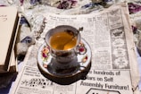 a cup of tea sitting on top of a newspaper