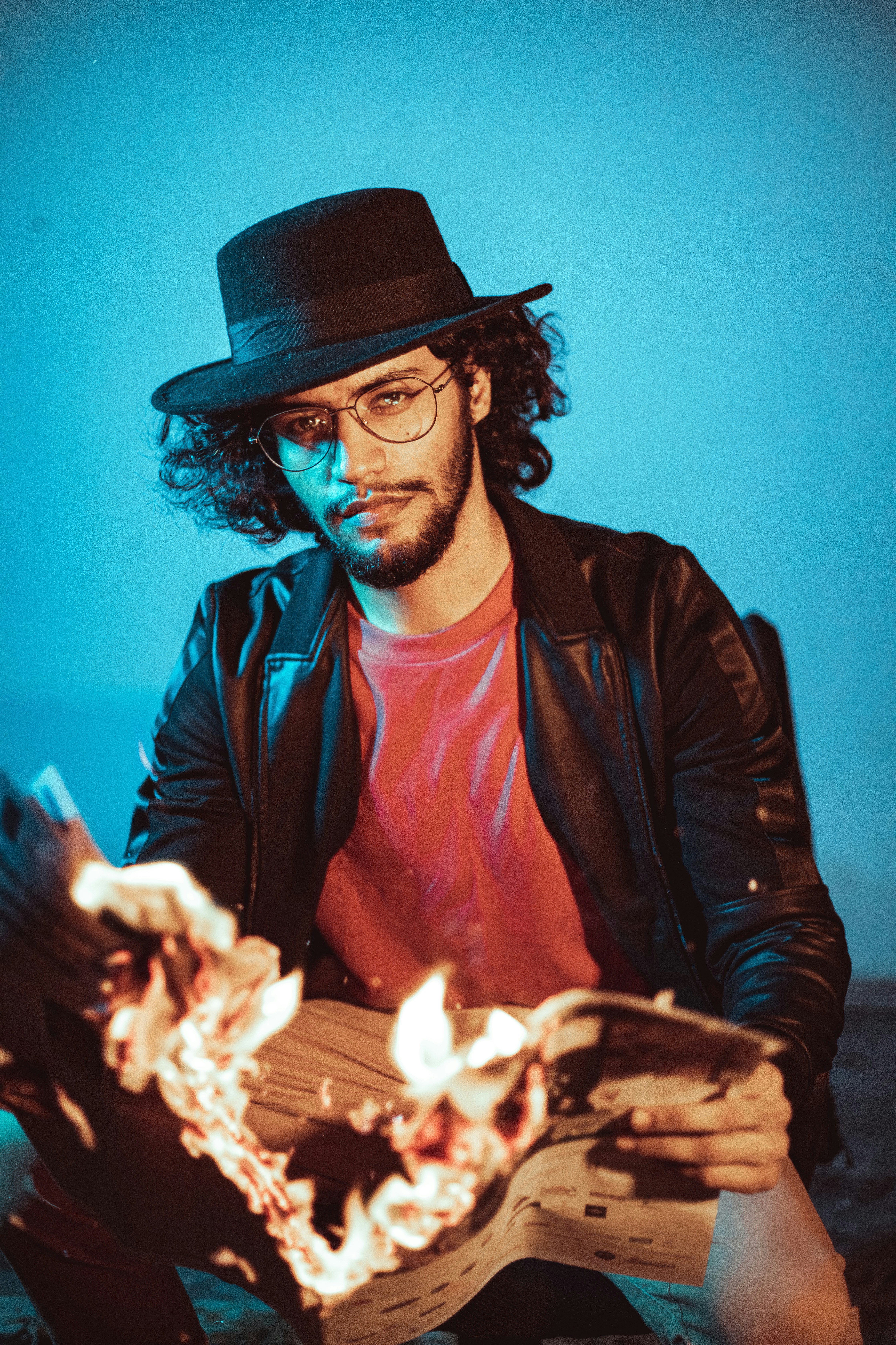 a man with a hat and glasses holding a guitar