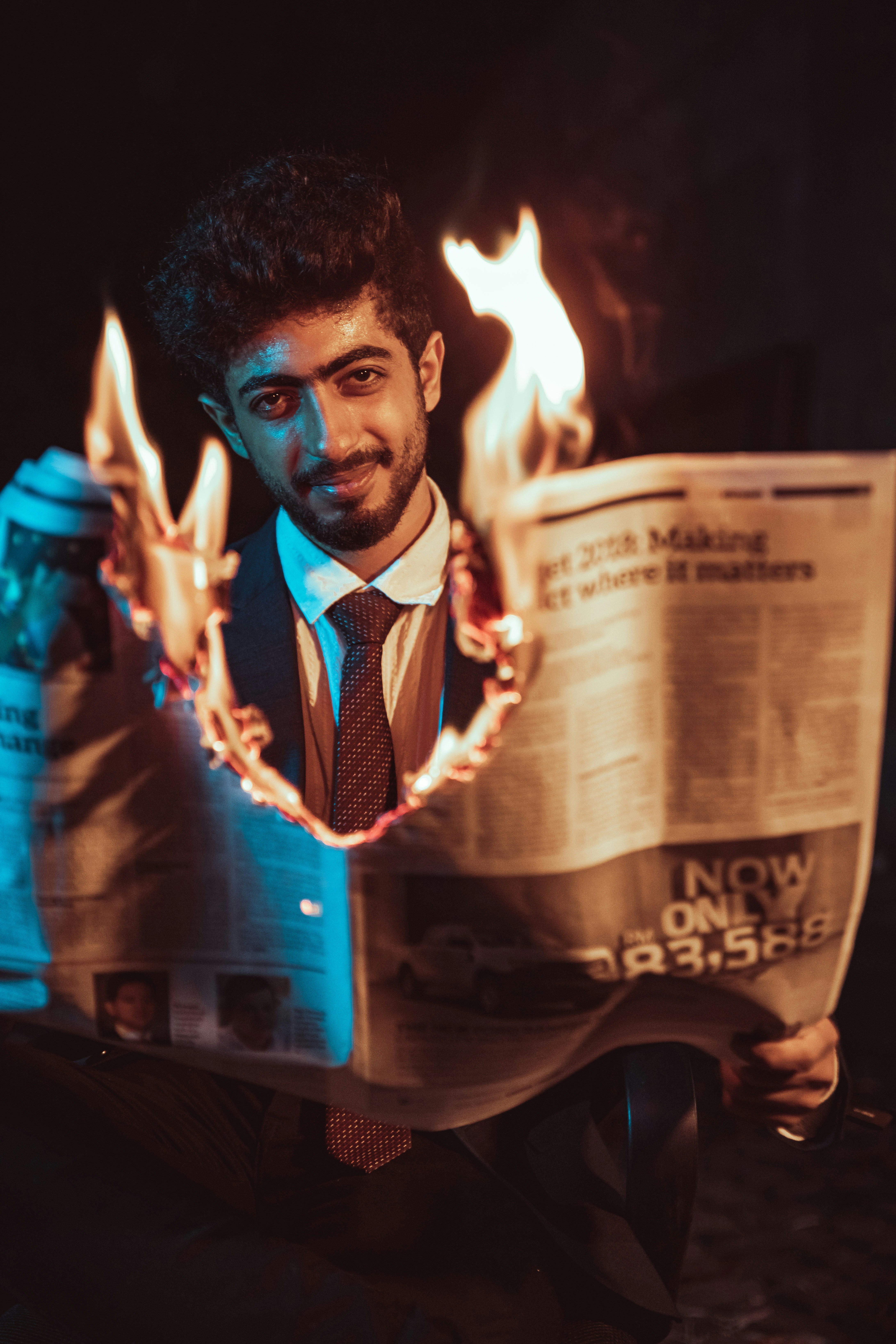 a man in a suit and tie reading a newspaper