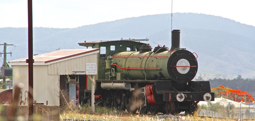 an old train sits on the tracks in front of a building