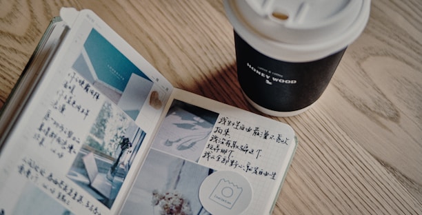 A warm photo of an open journal with handwritten notes and a pen resting nearby on a wooden table.