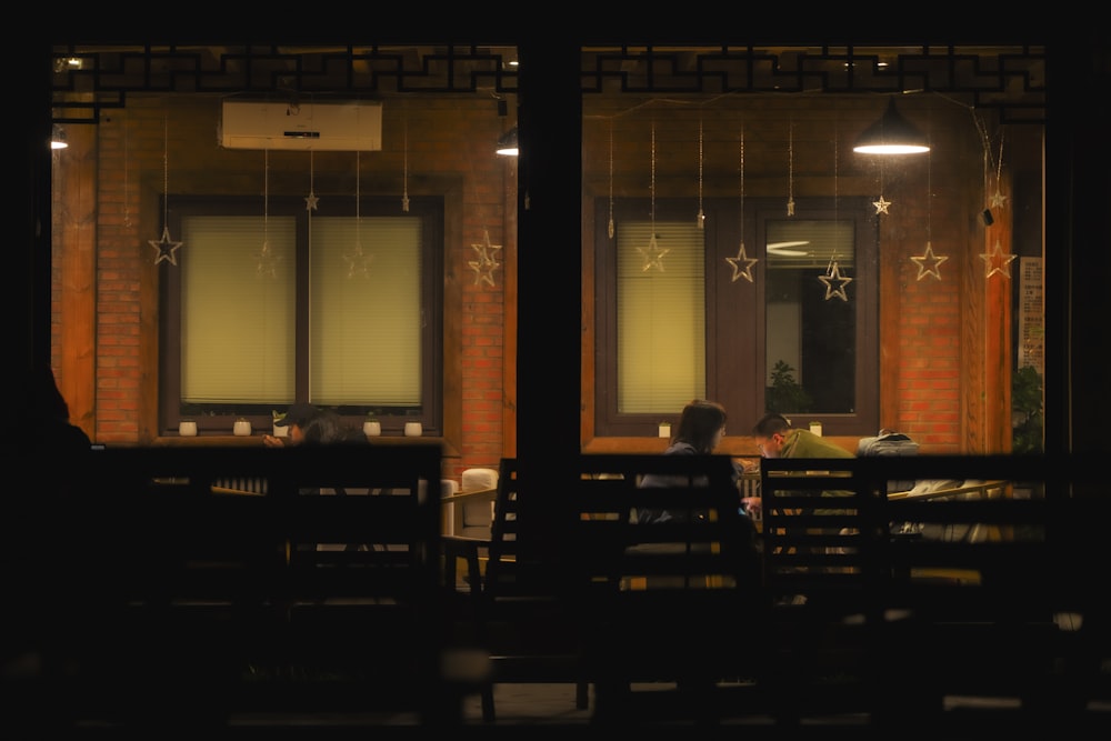 a person sitting on a bench in front of a window