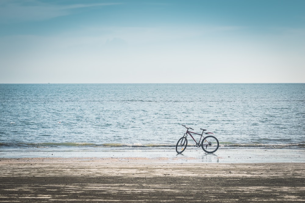 a bike is parked on the beach near the water