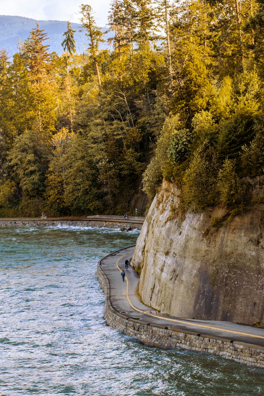 a man riding a surfboard on the side of a river