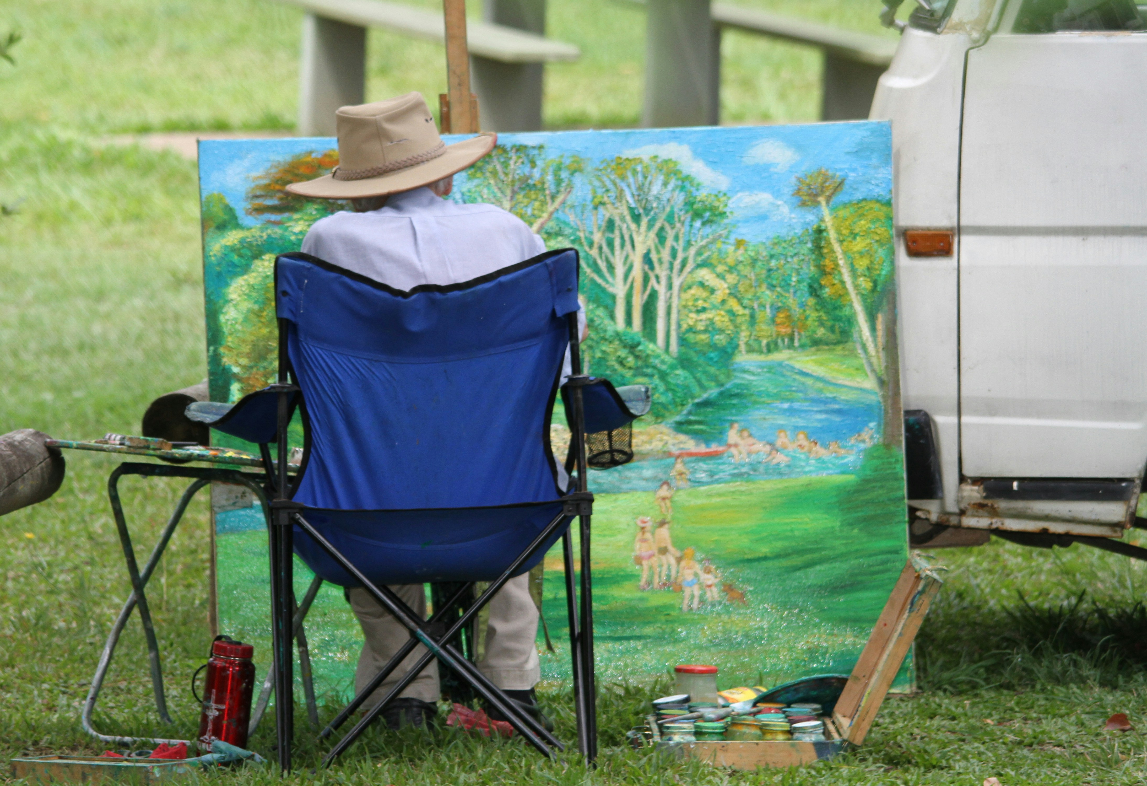 a man sitting in a chair in front of a painting