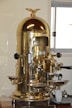 a gold colored coffee machine sitting on top of a counter