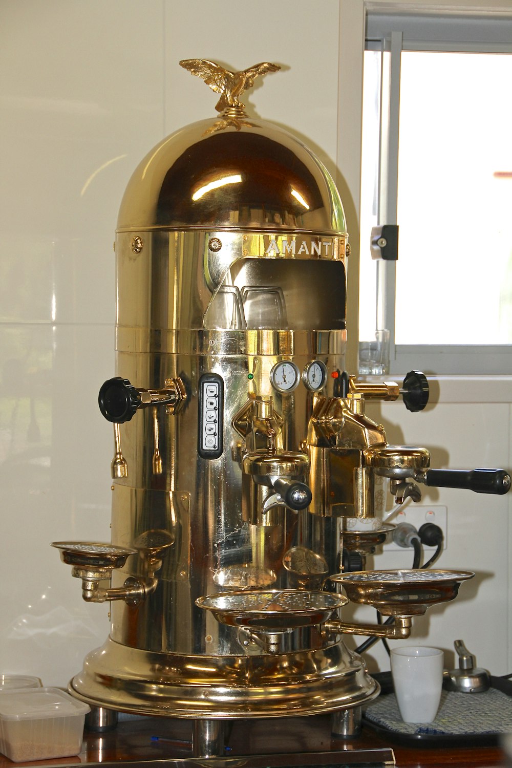 a gold colored coffee machine sitting on top of a counter