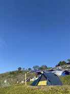 Campers setting up tents in a sunny clearing.