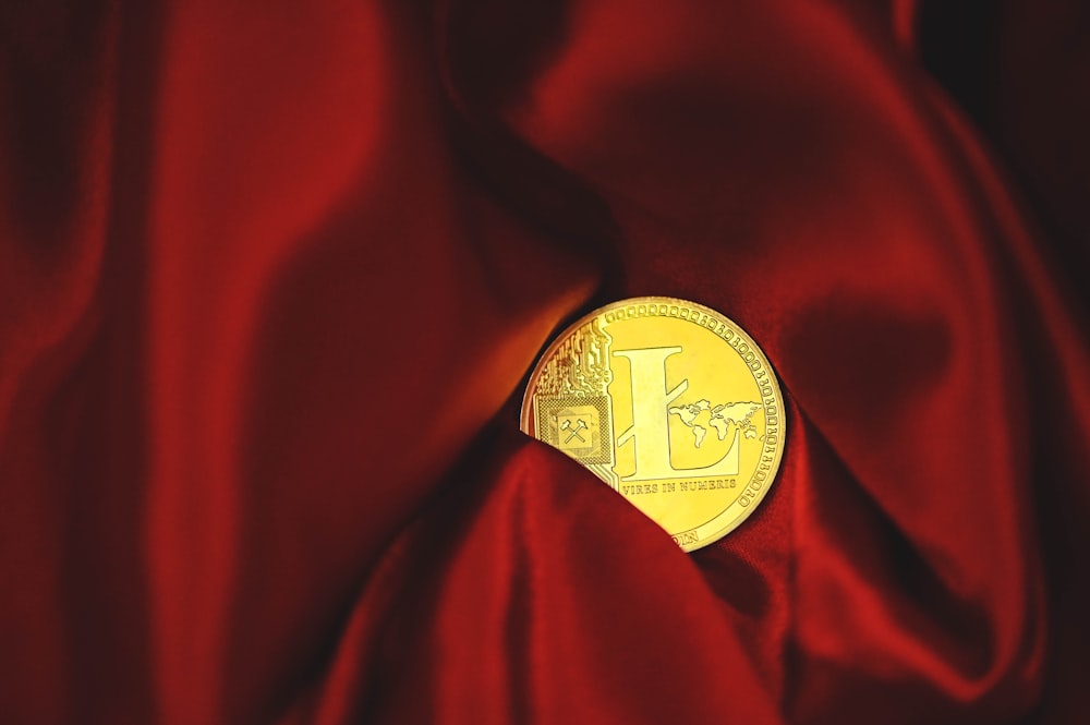 a close up of a gold coin on a red cloth