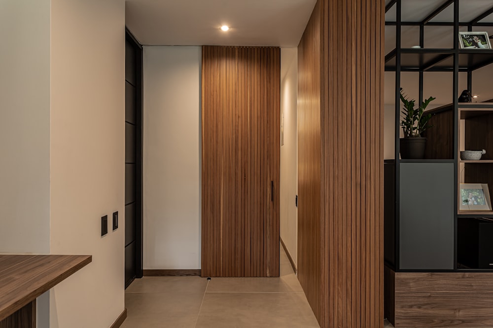 a hallway with a wooden door and a shelf