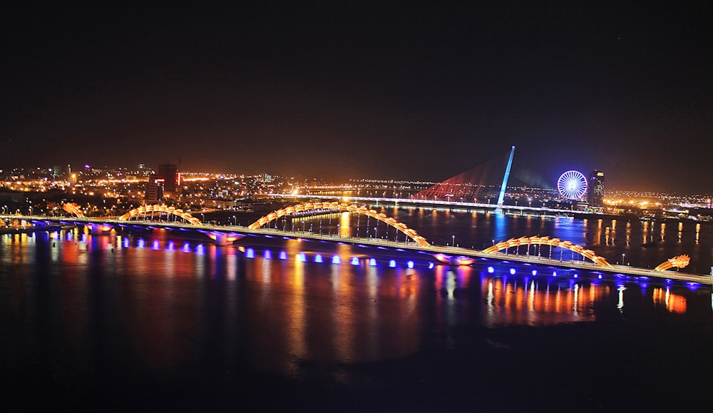 a bridge lit up at night over a body of water