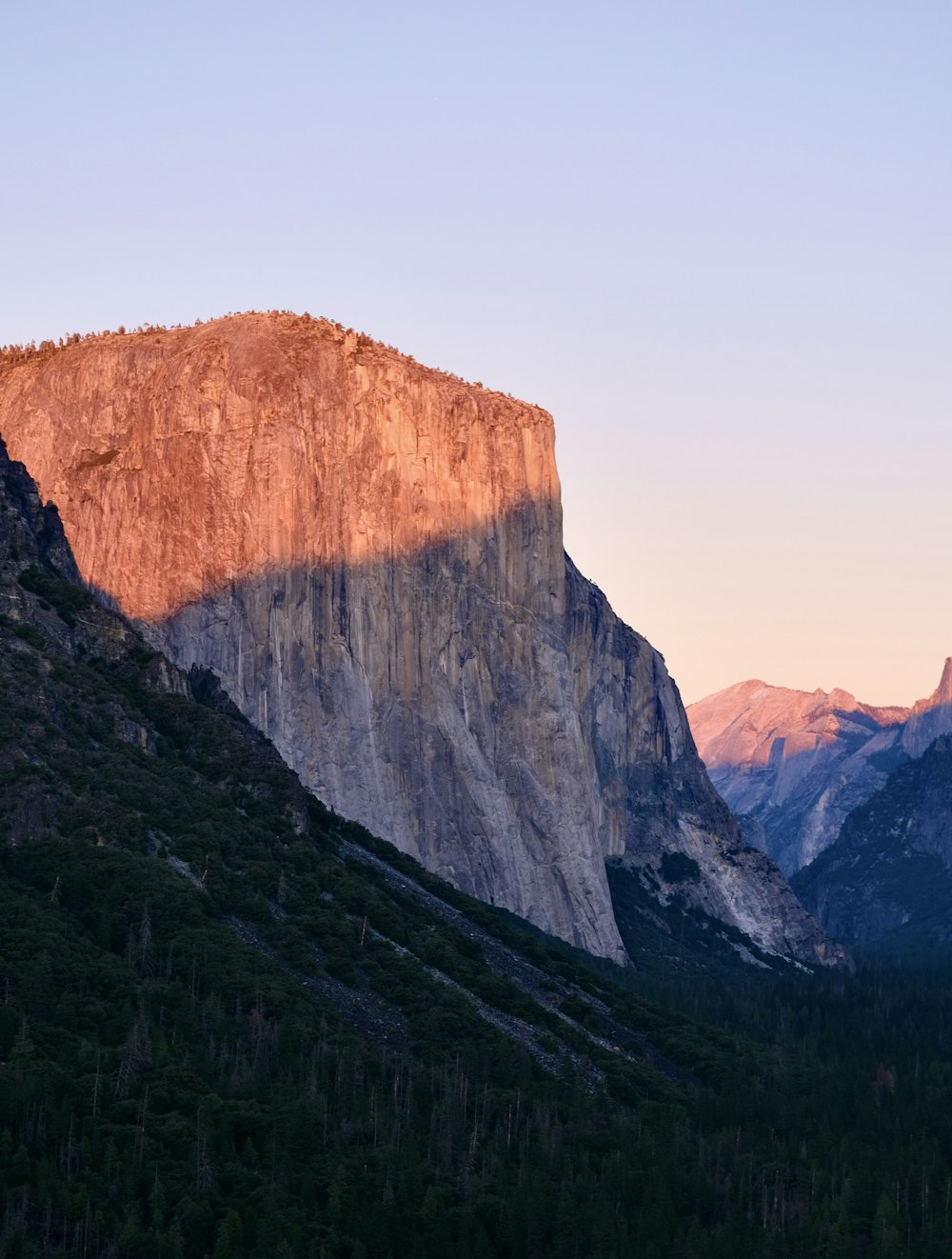 the sun is setting on the mountain side