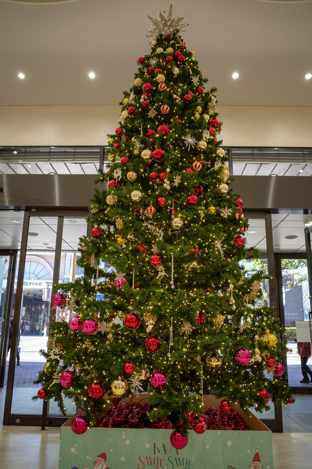 a christmas tree in a building with a sign underneath it