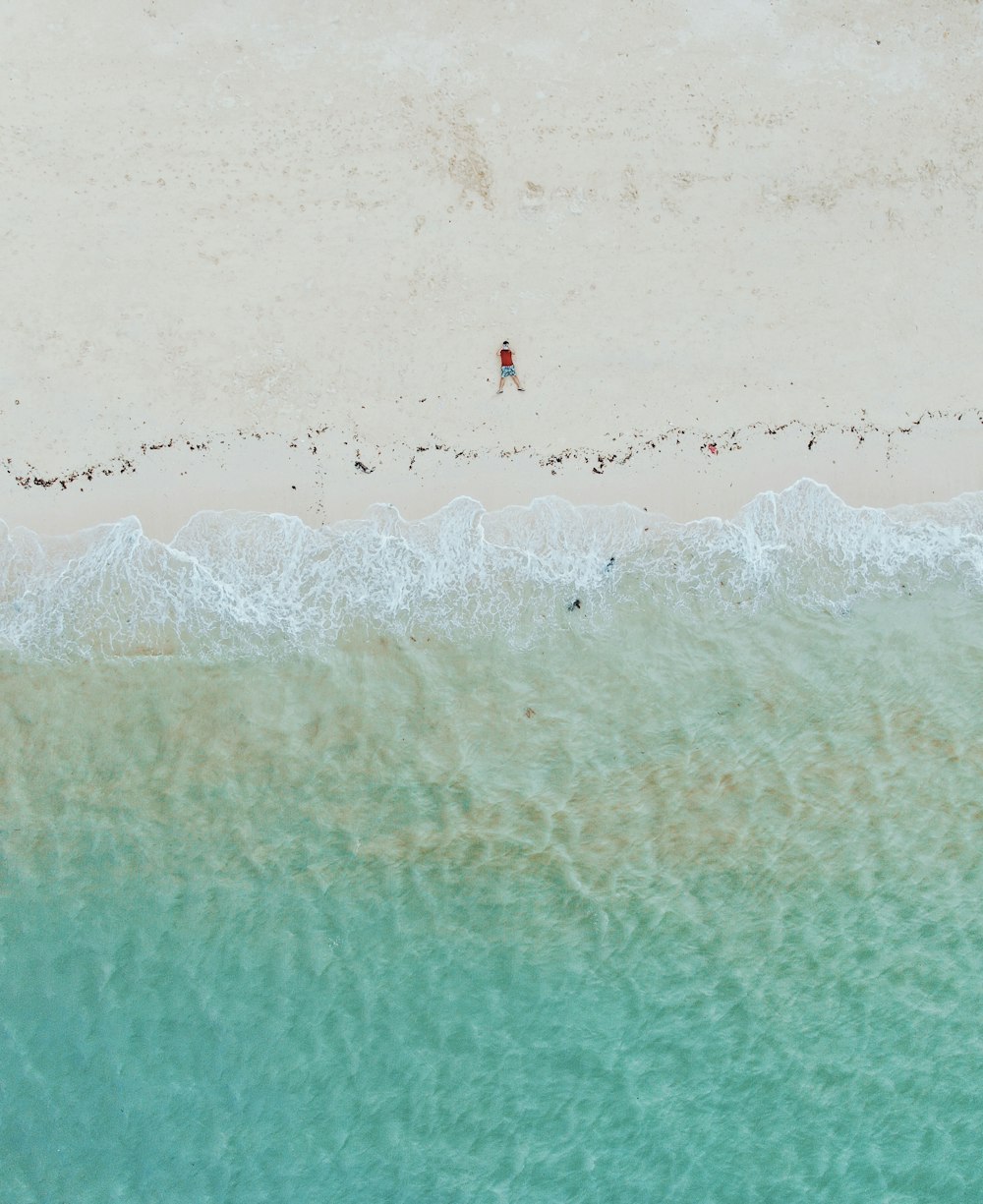 an aerial view of a beach with people walking on it